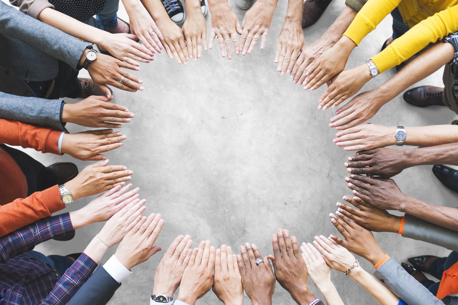 Mâinile angajaților CANCOM Austria reunite într-un cerc.